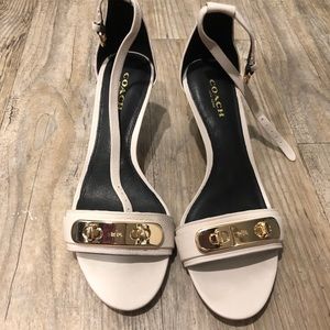 A pair of Coach white leather heels.